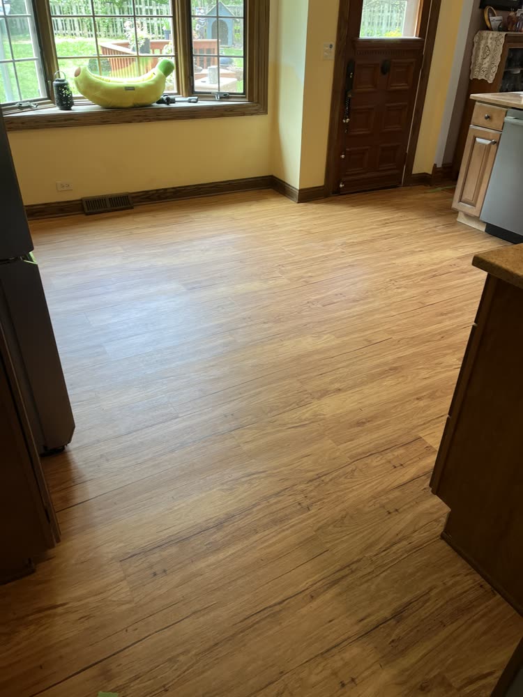 Hickory-look vinyl plank flooring in a kitchen and entryway