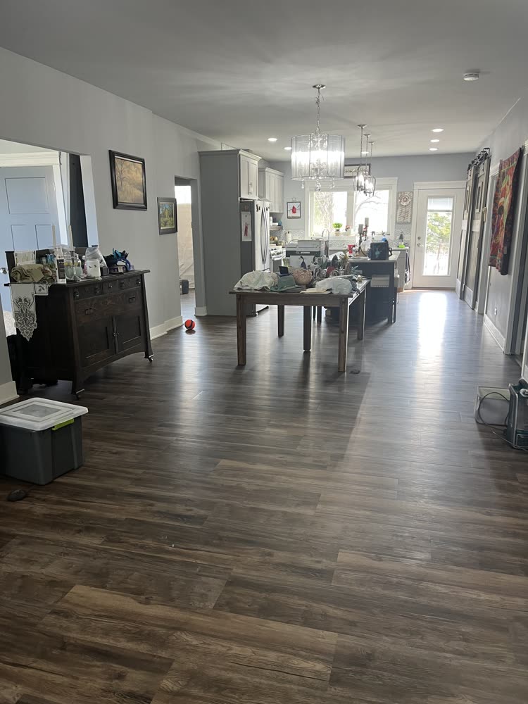 Dark rustic vinyl plank flooring running through an open concept living and dining area